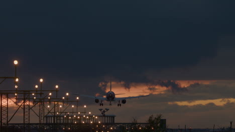 airplane landing at night under dramatic sky