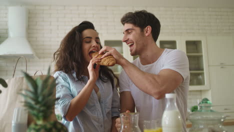 una pareja feliz tomando el desayuno en la cocina