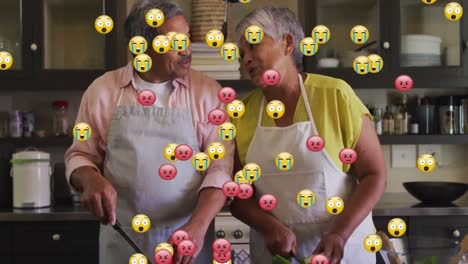 Animation-of-emojis-over-senior-couple-cooking-together-in-kitchen