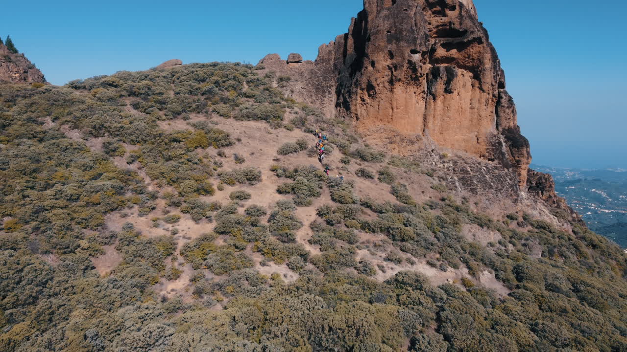 fantástica toma aérea a lo lejos del famoso roque saucillo y donde hay un grupo de turistas bajando la montaña