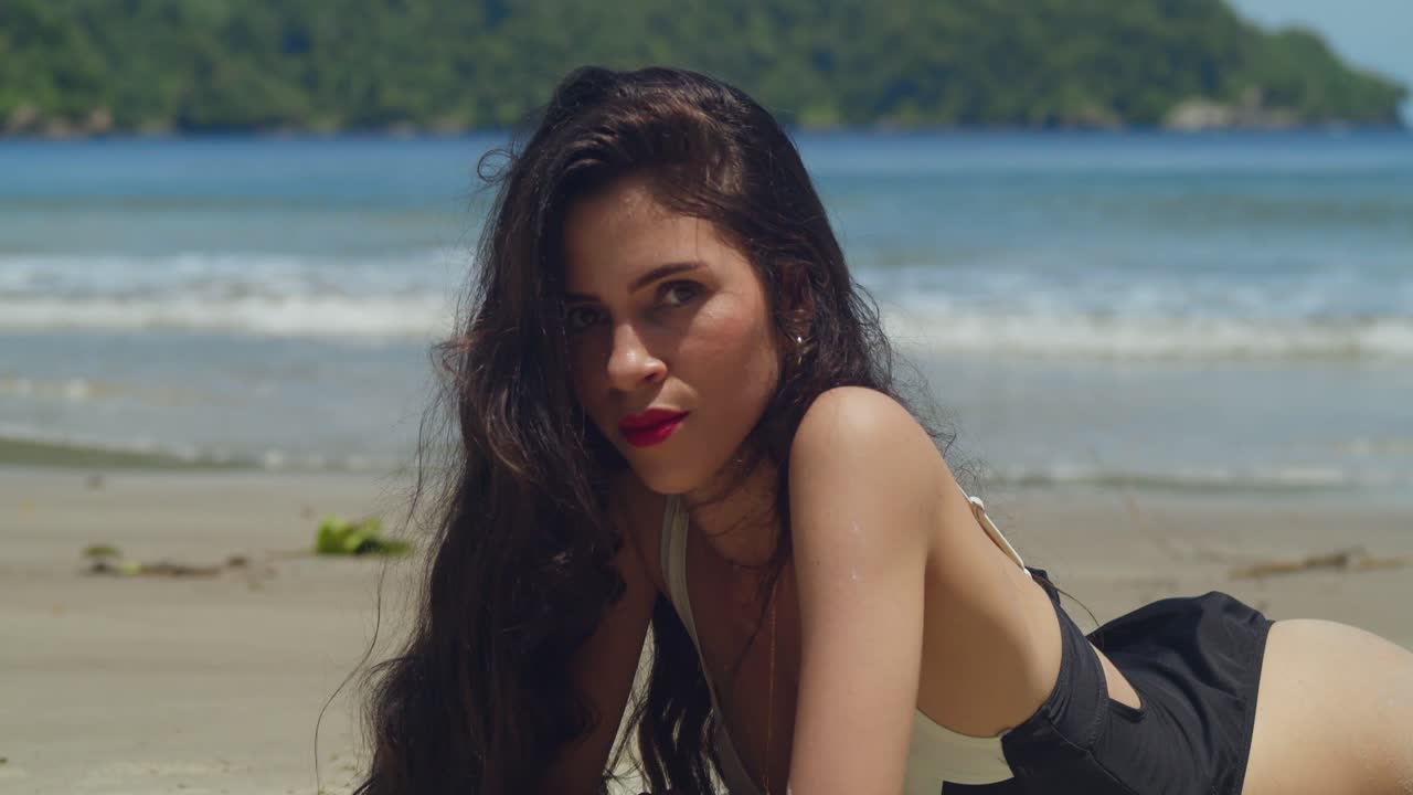A girl of Latina descent enjoys the warm sun in her bikini on a Caribbean beach.