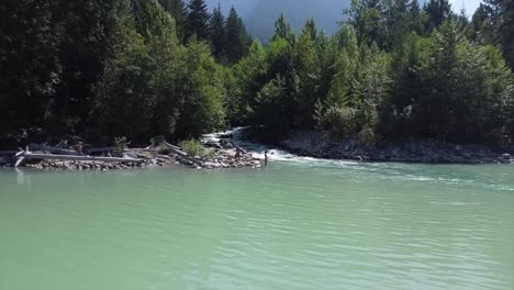 Mujer-En-Bikini-De-Dos-Piezas-Pescando-Con-Caña-De-Pescar-En-El-Lago-Lillooet,-BC,-Canadá