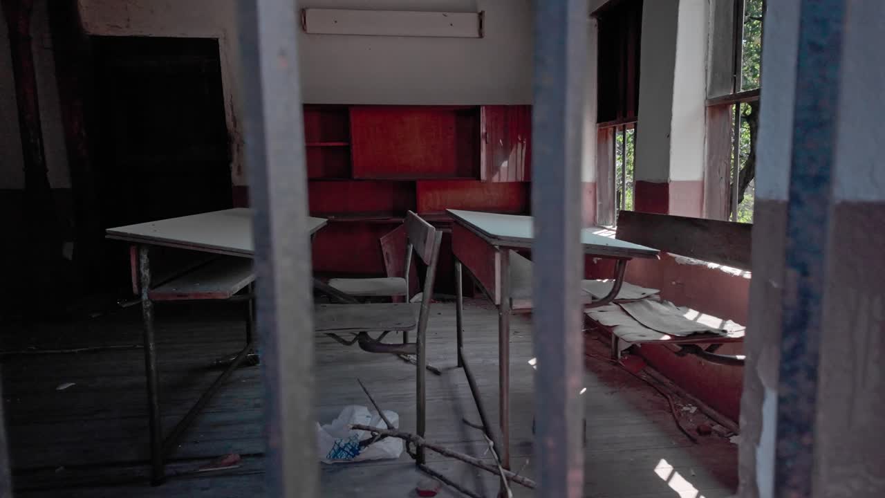 nostálgico abandonado desolado aula de la escuela a través de la ventana rota pan tiro