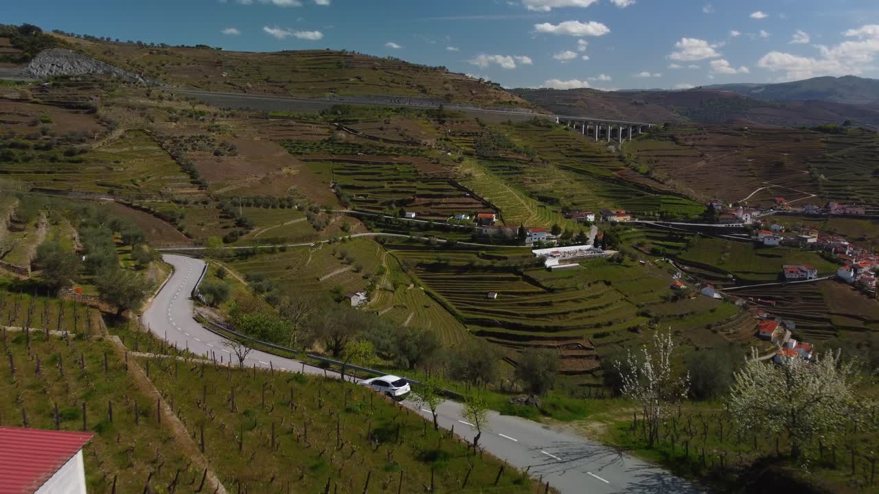volo drone che segue un'auto su una strada tortuosa tra le montagne del nord portoghese e i campi di vino