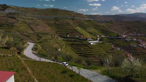 drone flight that follows a car over a winding road between the northern portuguese mountains and wine fields