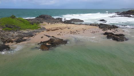 outcrops at bonville headland lookout with foamy waves at sawtell beach in new south wales, australia