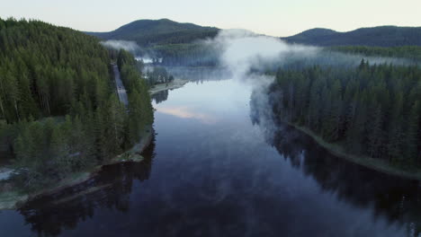 Lowering-low-over-the-water-of-a-misty-lake-with-calm-reflective-water