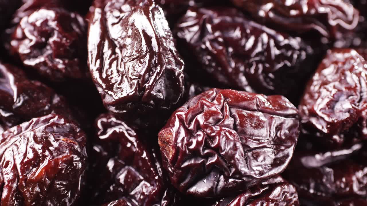 Close up view of hands picking dried plums