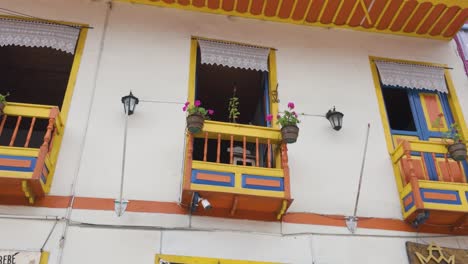 mirando hacia arriba a los coloridos balcones de madera de estilo colonial con macetas colgantes en filandia colombia