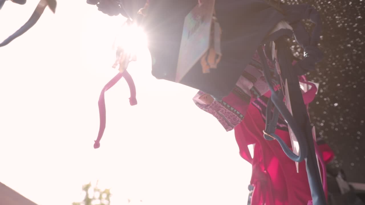 close up of a row of clothes for sale on the roadside. shoot from below with the seepage of sunlight