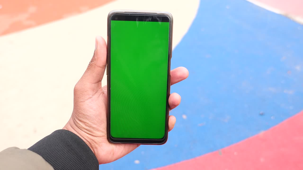 persona con un teléfono inteligente con pantalla verde