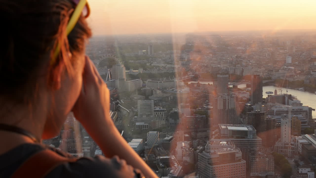 turista tomando una fotografía de la puesta de sol en el horizonte de londres vista desde el fragmento