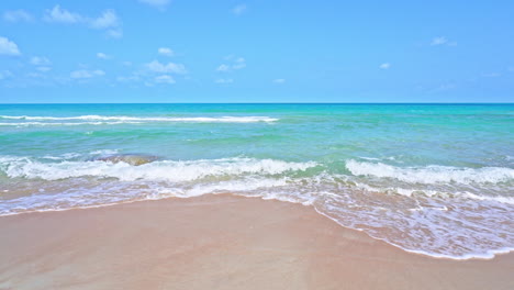 Zeitlupe-Von-Wellen,-Die-Sich-über-Einen-Sandstrand-Ausbreiten