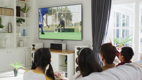 composite of happy family sitting at home together watching hockey match on tv