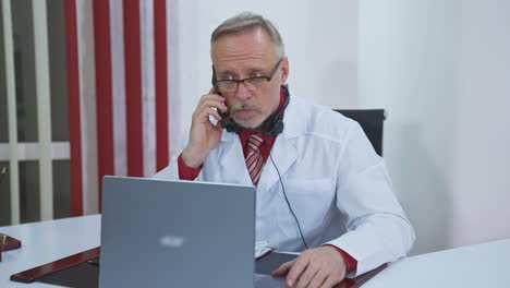 professional doctor talking with patient on cellphone. male doctor in white medical uses phone to make remote consulting of patient. online medical consultation.