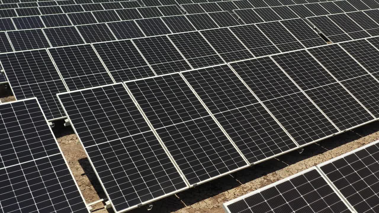aerial close up view a solar plant farm utilizes photovoltic panels to generate electricity.4k video