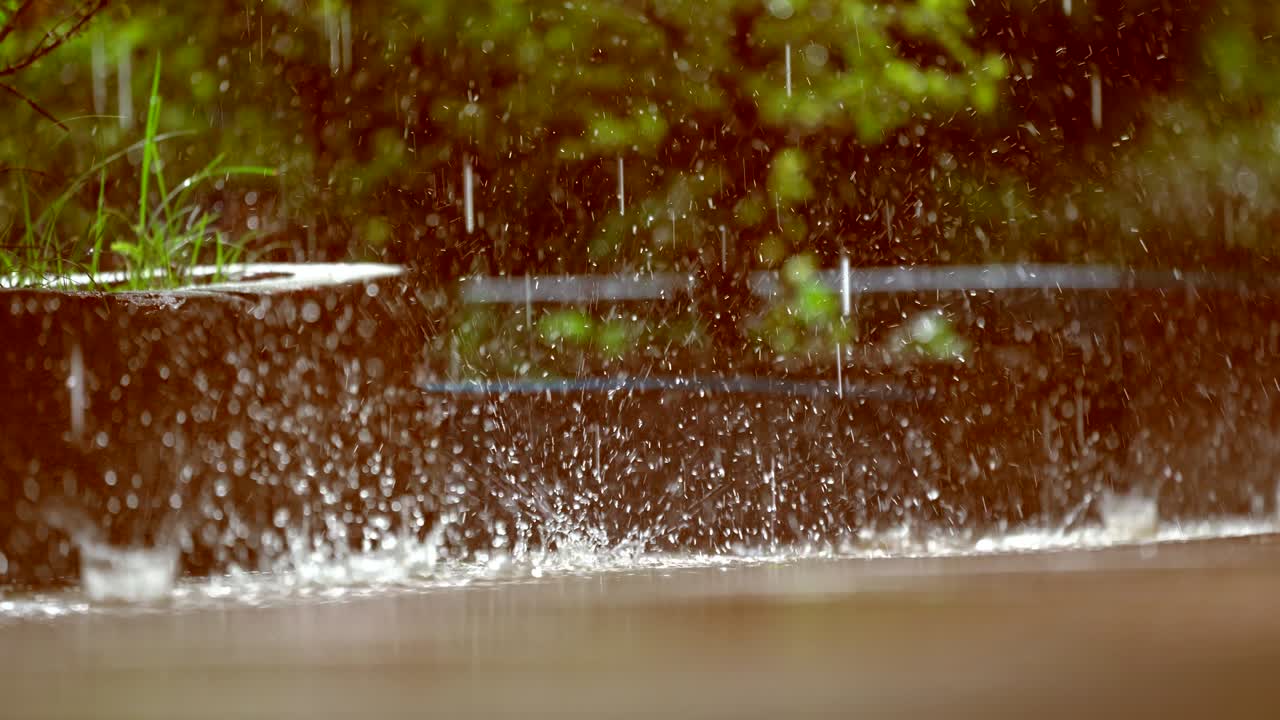 Rain droplets falling on ground on blurred background, beautiful nature rain season, splash of water fall motion on ground, light of sunny pass water is beauty, close up view raindrop on heavy weather