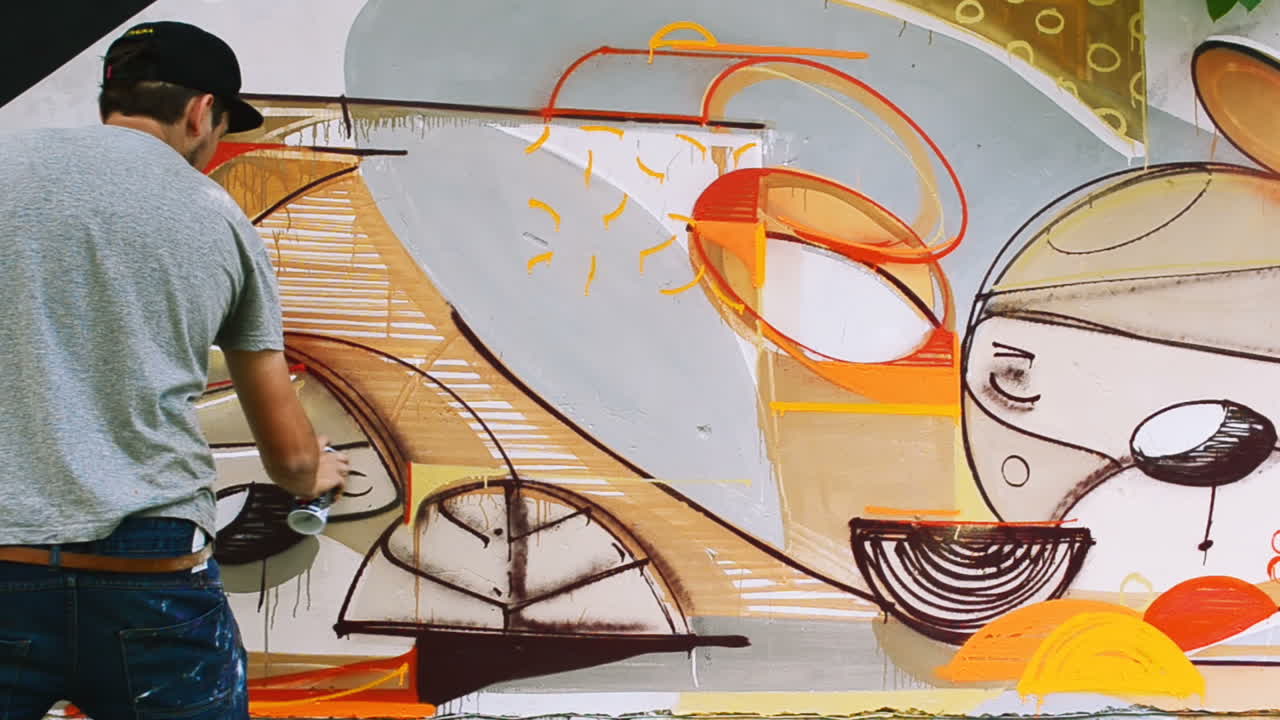 O artista desenha grafite em uma cerca. Desenho abstrato