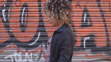 stylish black woman against graffiti