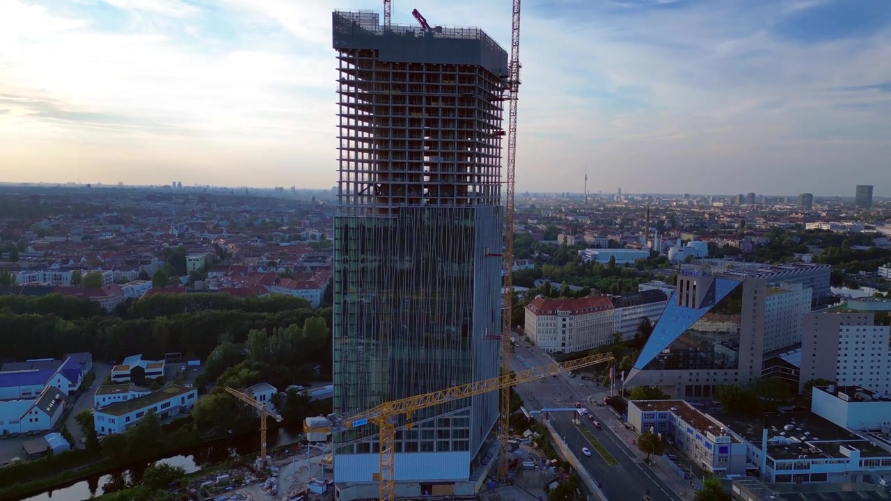 Cantiere della torre Estrel a Berlino 2024, con gru e skyline sullo sfondo. Bella ripresa aerea con drone in volo e inclinazione verso l'alto