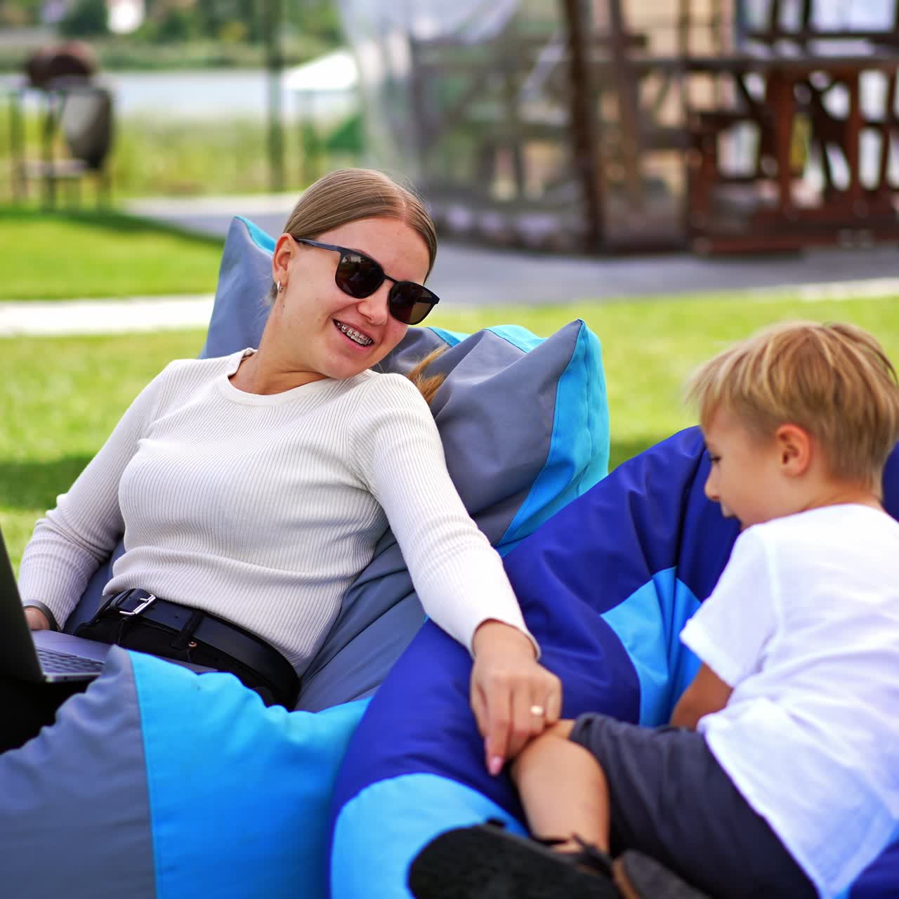 Ung kvinde med barn, der har det sjovt udendørs. Glad familie og barn i parken