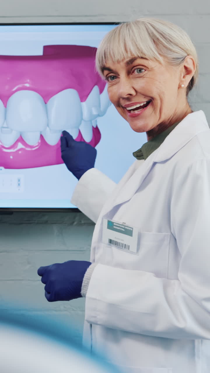 Dentista senior che spiega un modello dentale 3D sullo schermo
