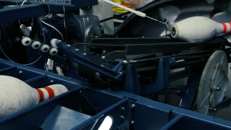 closeup of bowling pins resetting in a pinsetter machine