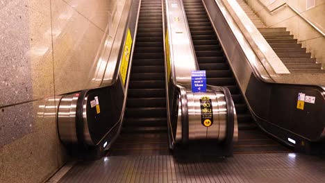 a sequence of escalator rides in a bangkok mrt station, highlighting modern architecture and ambient lighting