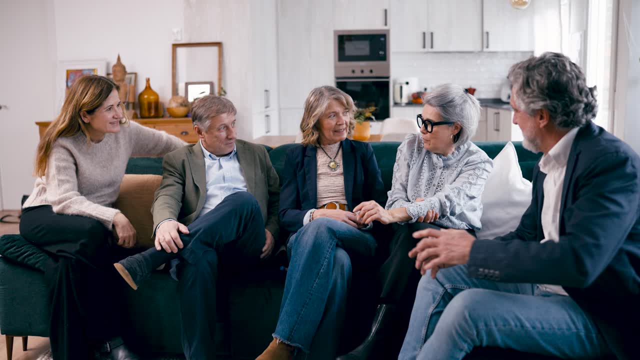 Gruppe af venner snakker og hygger sig på en sofa i et moderne hjem