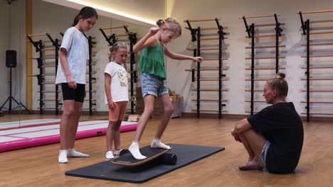 niños practicando ejercicios de equilibrio con un instructor