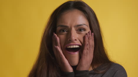 retrato de estudio de una mujer emocionada celebrando buenas noticias ganando dinero contra un fondo amarillo 4