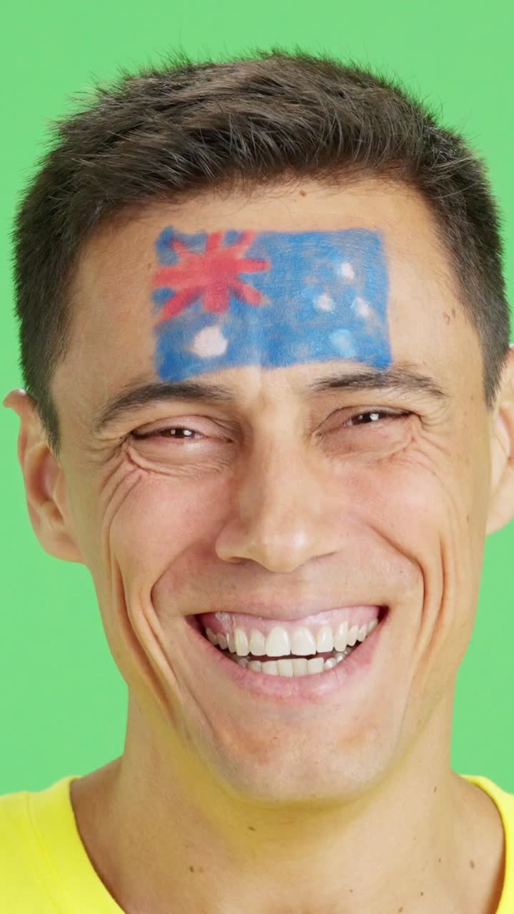 Man with a australian flag painted on the face smiling