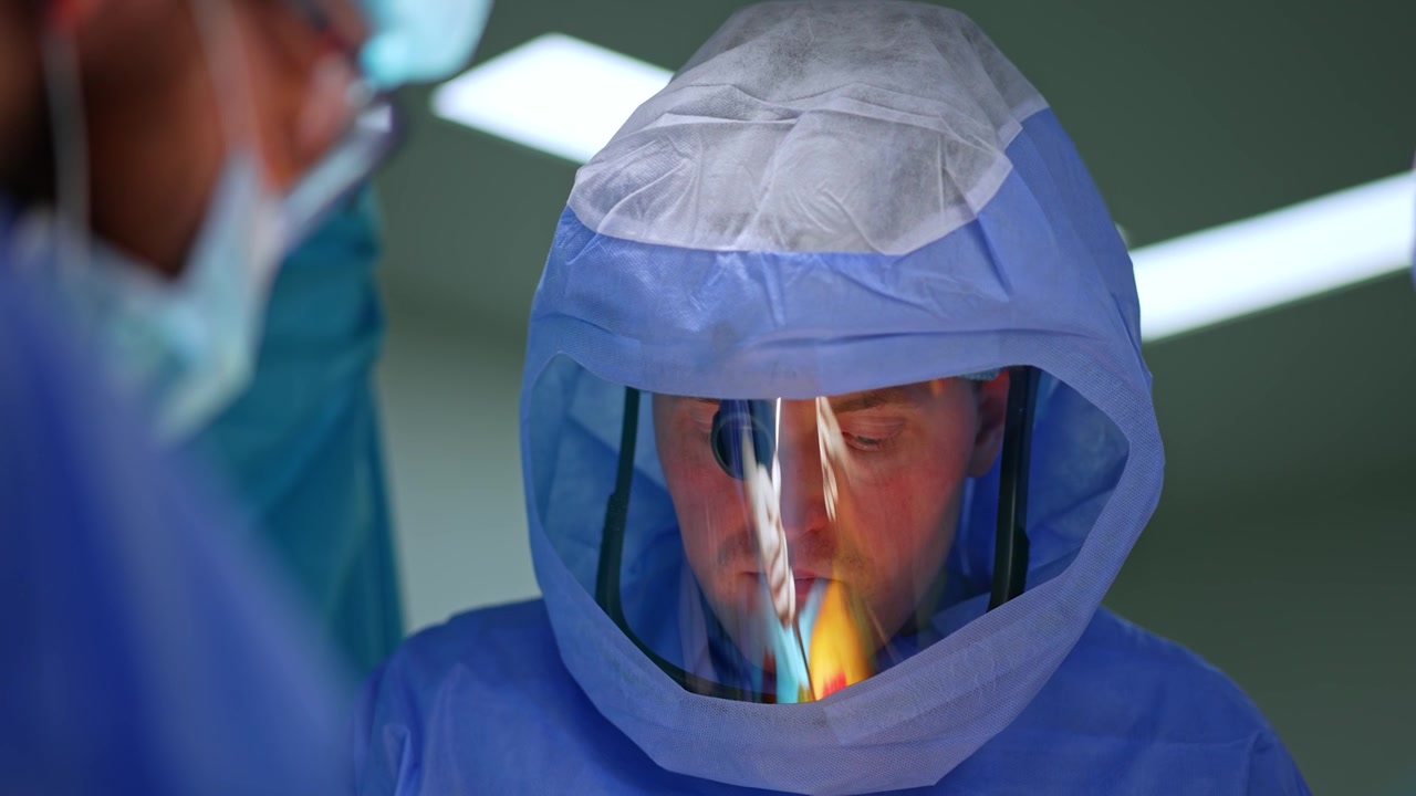 Ritratto di un medico uomo calmo e sicuro di sé con casco protettivo. Il medico sta operando su un trauma.