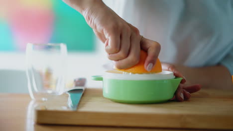 Woman-hands-making-natural-orange-juice-on-wooden-board