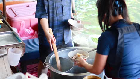 vendor preparing noodles at a floating market