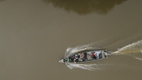 Top-Down-Aerial-View-of-Motorboat-Sailing-in-Muddy-River-Water,-Dramatic-High-Angle-Drone-Shot