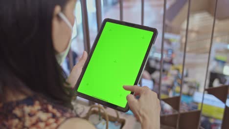 mujer usando tableta digital en el centro comercial, llave de chroma