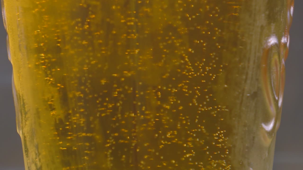 Slow Motion Close Up of Refreshingly Cool Lager Beer with Details on Bubbles Rising on Hot Sunny Day. Alcohol Beverage Footage 4K.