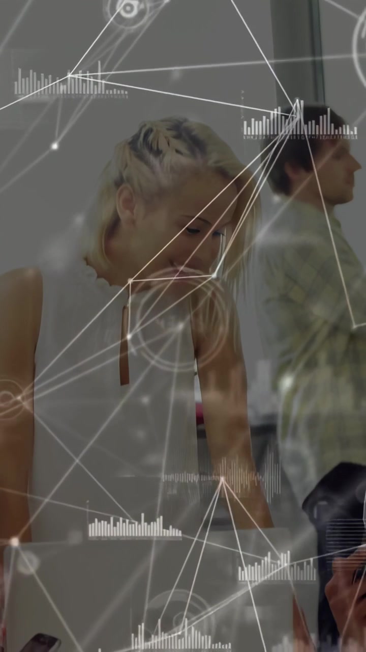 Vertical video: Woman leaning over desk, viewing device and activating HUD for tech collaboration