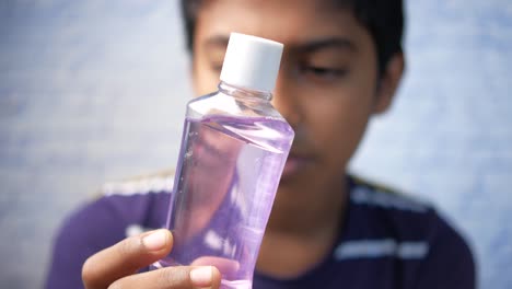 hand hold a mouthwash liquid container