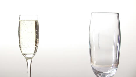 Animation-of-burning-paper-over-champagne-glasses-on-white-background