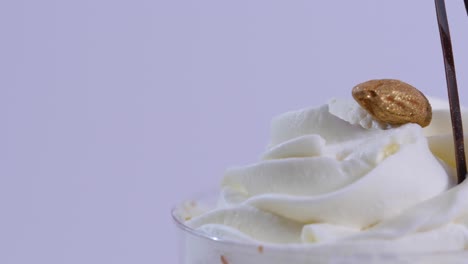 close-up of a dessert with whipped cream and gold-leaf almond