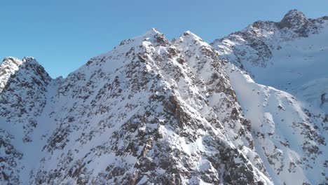 vista aérea alrededor de los picos nevados y rocosos de las montañas, en el soleado kaunertal, austria - dando vueltas, tiro de drones