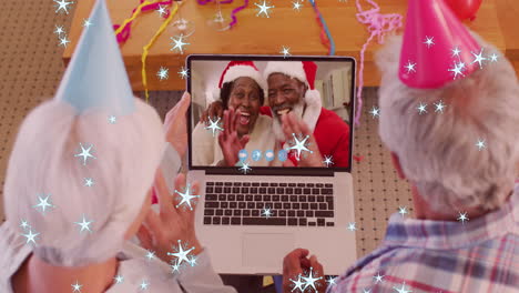 animation of stars falling over senior caucasian couple on laptop video call at christmas