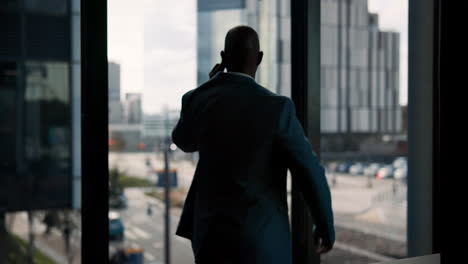 man in suit looking out window