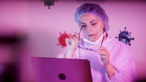 young woman scientist tired on studying coronavirus statistics on laptop inside laboratory, removes glasses
