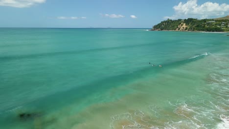 surfistas esperando la próxima ola en la playa de agua caliente en nueva zelanda