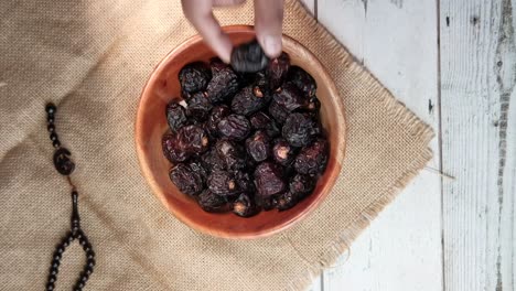 hand reaching into a bowl of dates