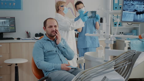 dentistry patient expressing serious toothache in oral care cabinet