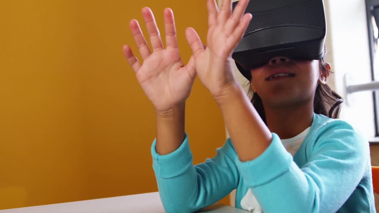 Schoolgirl using virtual reality glasses in classroom at school